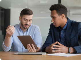 Man going over chart comparing checking accounts with another man in suit.