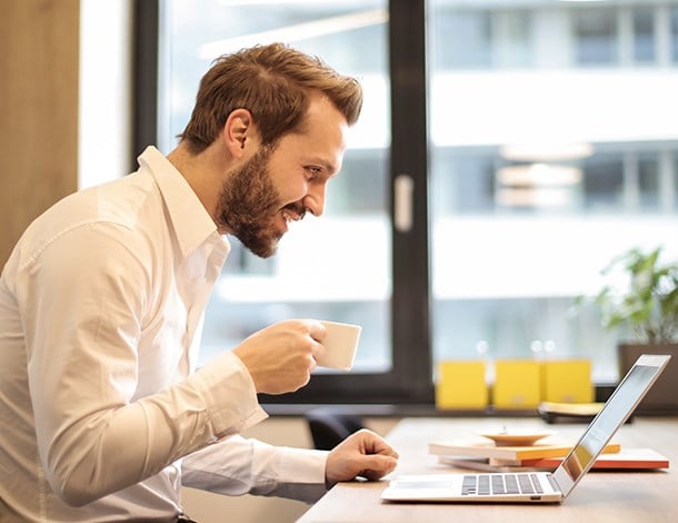 Man on laptop with coffee mug